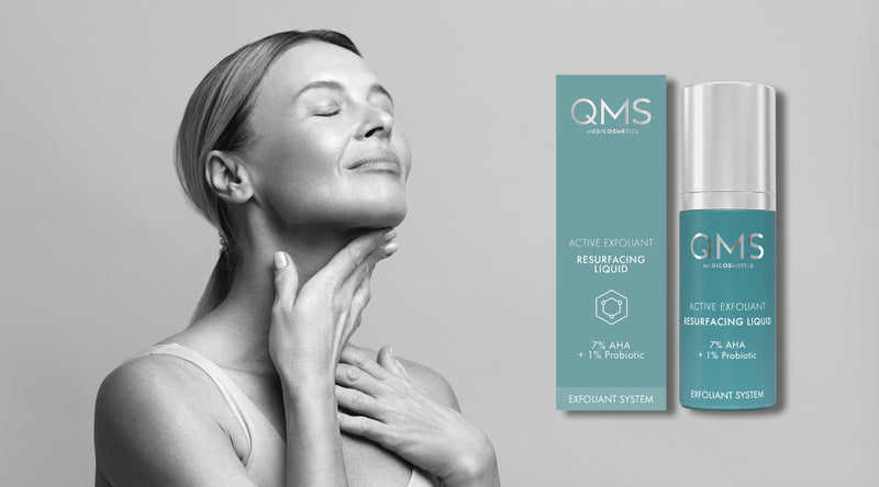Woman touching her neck with a QMS skincare product on a gray background